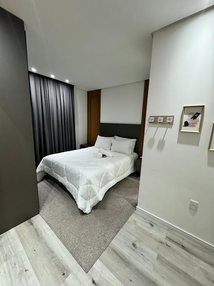 Chic modern bedroom interior featuring cozy bedding, wooden accents, and soft lighting.